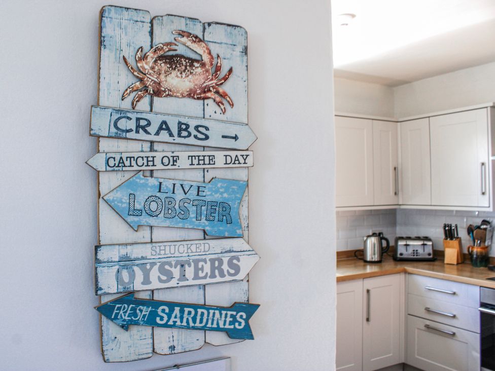 A kitchen featuring a sign and appliances at Waders in Salcombe