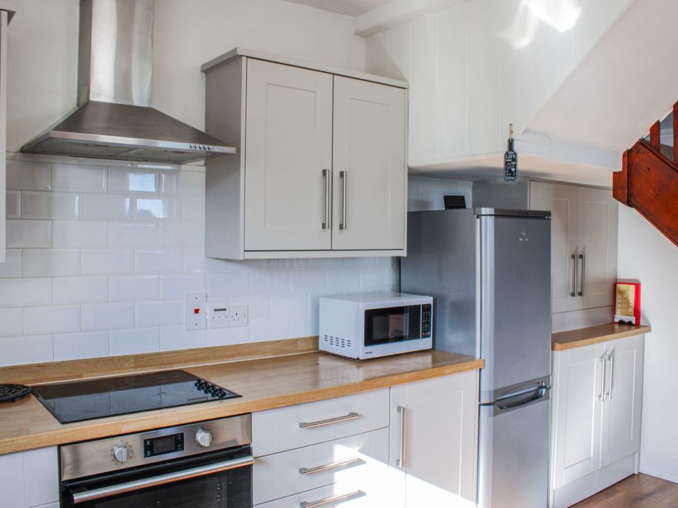 A kitchen with a stove, microwave, and refrigerator at Waders in Salcombe