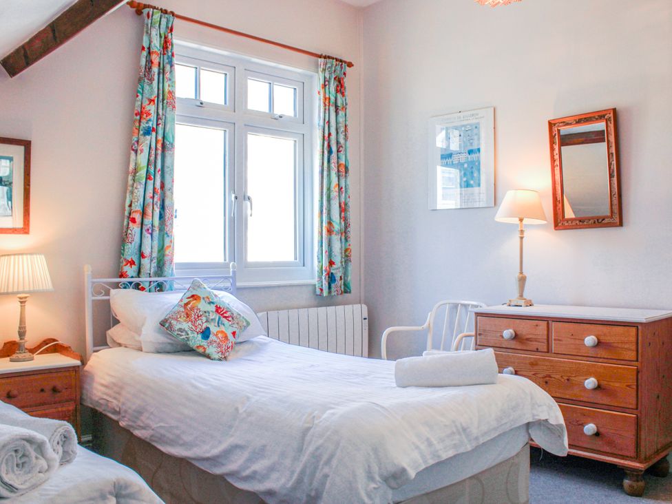 A bedroom with two beds and a lamp at Waders in Salcombe