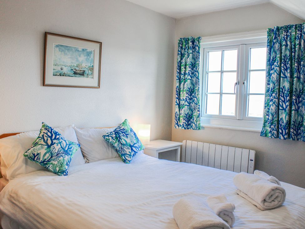 A bedroom with a bed and window at Waders Salcombe