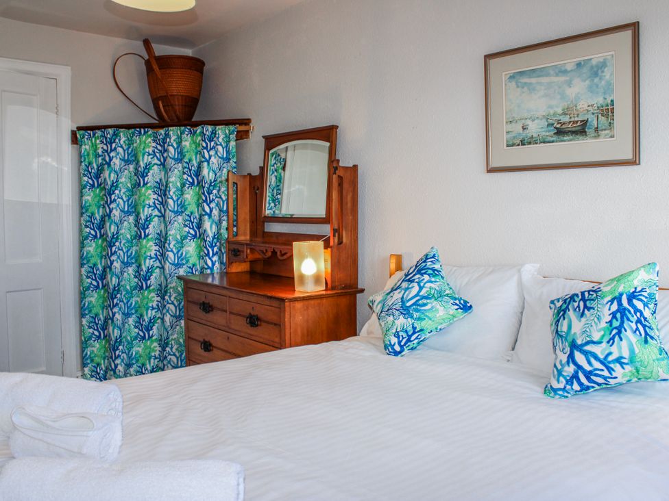 A bedroom with a bed and dresser at Waders in Salcombe