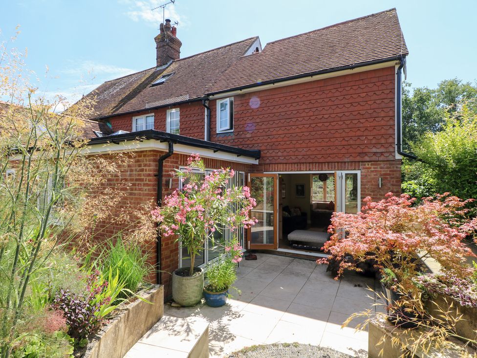 A garden with plants and a house at Cherry Garden Cottage in Sandhurst