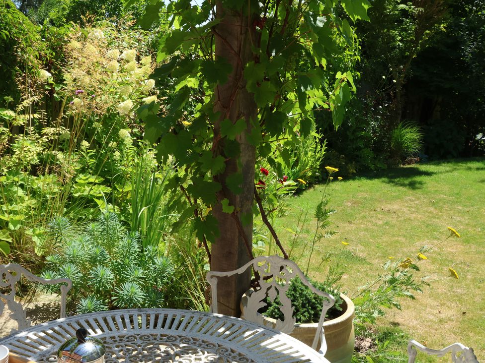 A garden with a table and chairs at Cherry Garden Cottage in Sandhurst