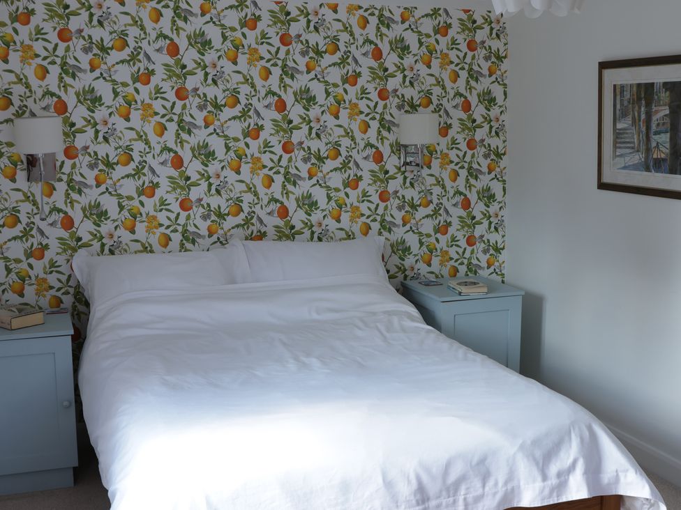 A bedroom with a bed and nightstands at Cherry Garden Cottage Sandhurst