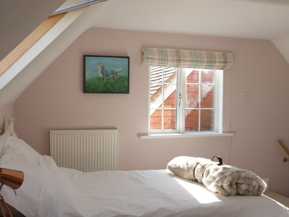 A bedroom with a bed and a painting at Cherry Garden Cottage Sandhurst