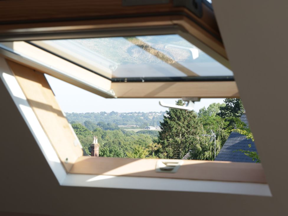 A window view showing trees and landscape from the attic at Cherry Garden Cottage Sandhurst
