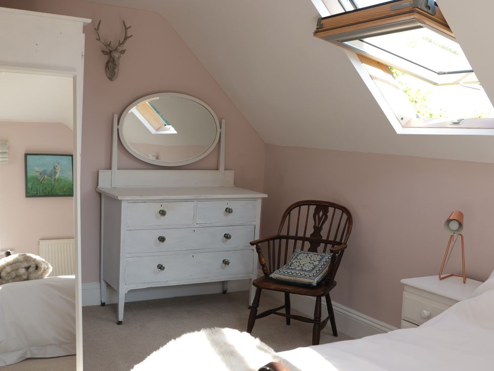 A bedroom with a dresser and a chair at Cherry Garden Cottage Sandhurst