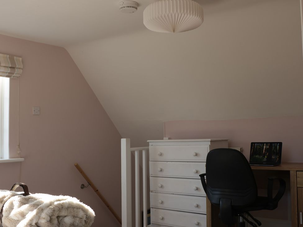 A room with a chair, desk, dresser, and window at Cherry Garden Cottage in Sandhurst