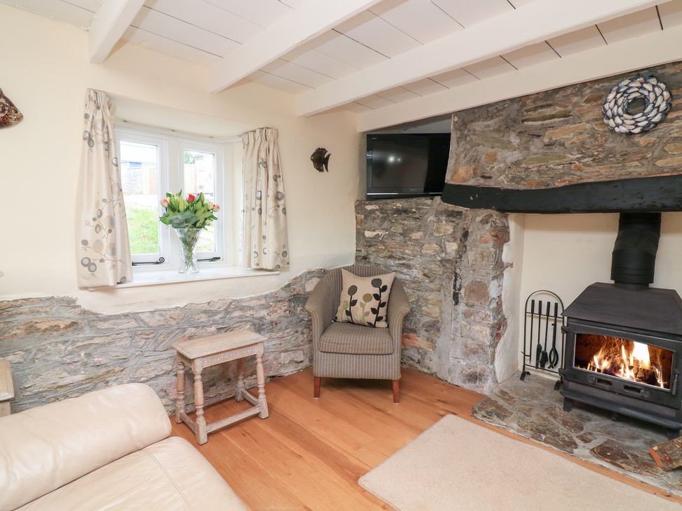 A living room with a fireplace and armchair at Wayside near Kingsbridge