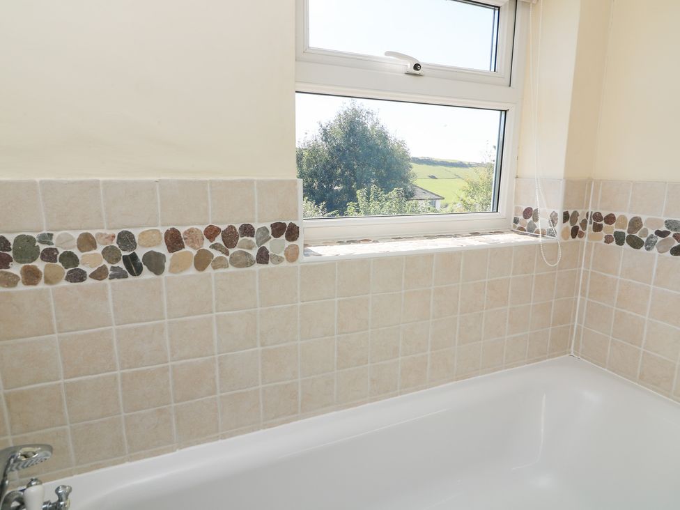 A bathroom with a bath tub and window at Wayside near Kingsbridge