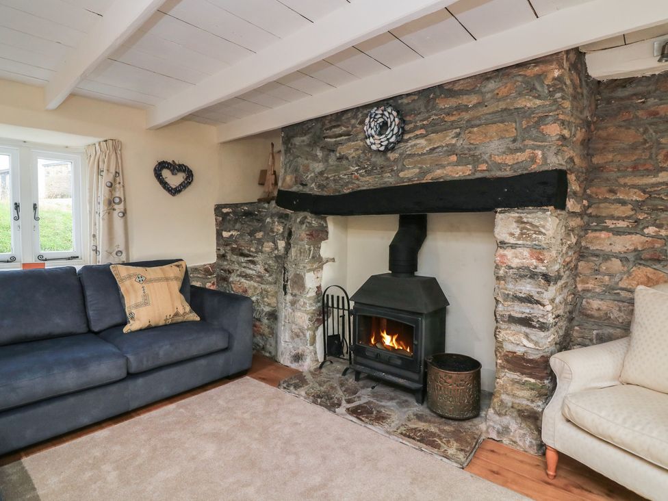 A living room with a fireplace and sofa at Wayside near Kingsbridge