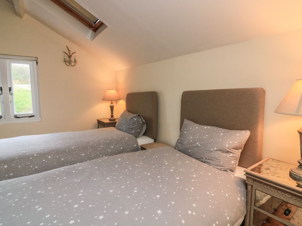 A bedroom with two single beds and a nightstand at Wayside near Kingsbridge