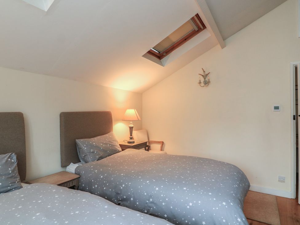 A bedroom with two beds and a lamp at Wayside near Kingsbridge