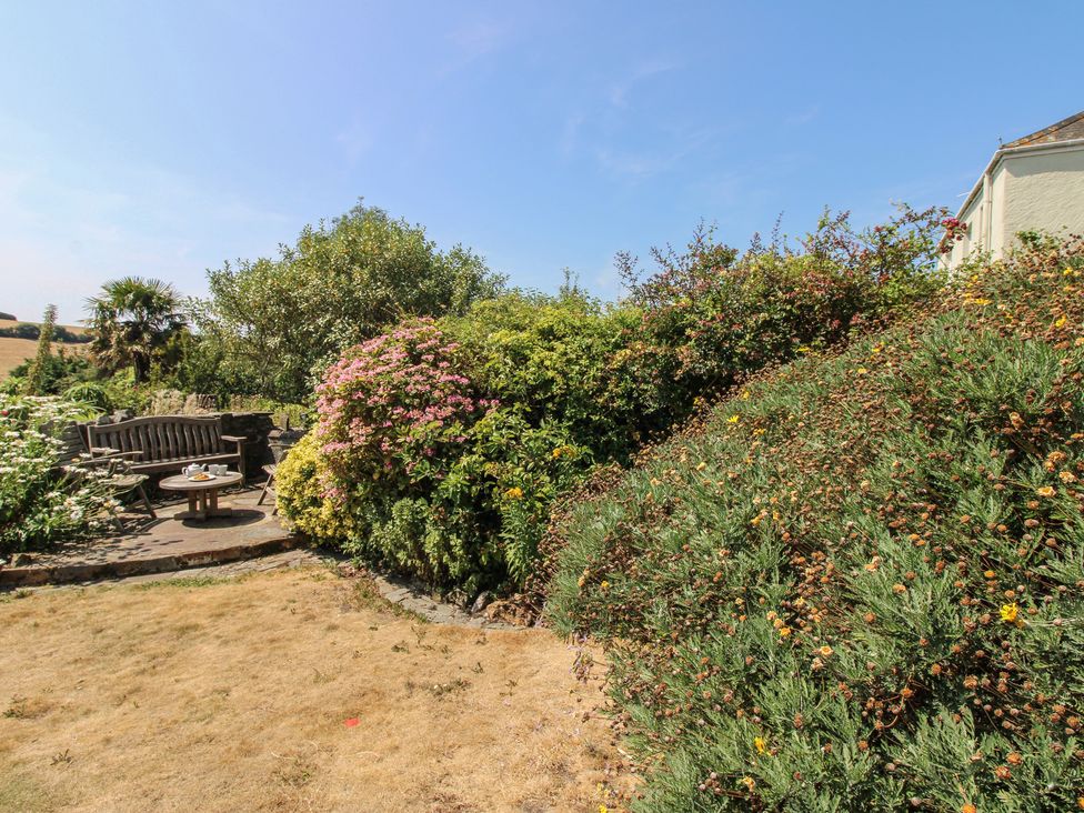 A garden with a bench and table at Wayside near Kingsbridge
