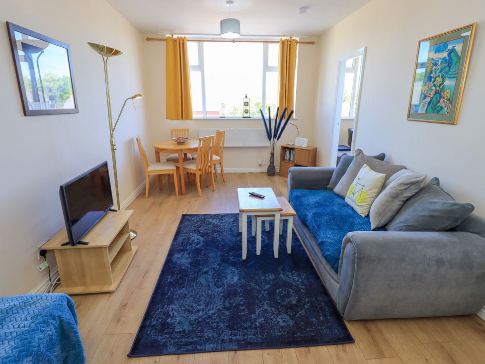 A living room with a sofa and a dining table at The Nest in Lytham St. Annes