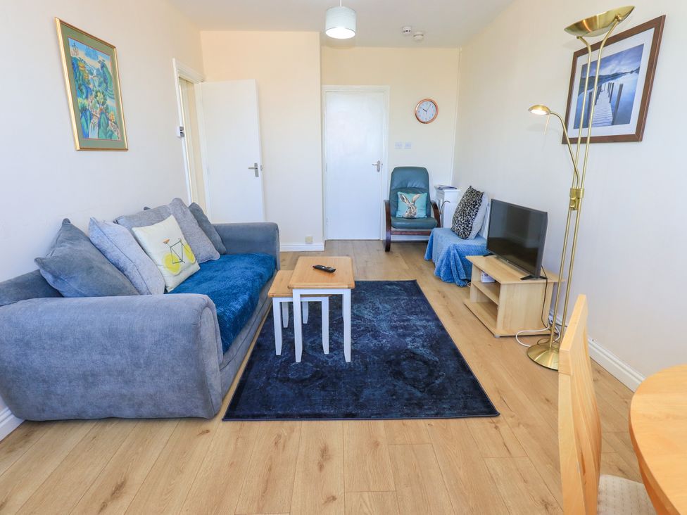 A living room with a sofa, coffee table, and television at The Nest in Lytham St. Annes