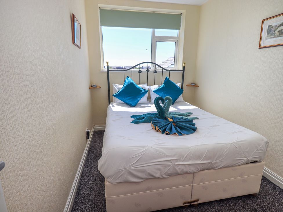 A bedroom with a bed and decorative pillows at The Nest in Lytham St. Annes