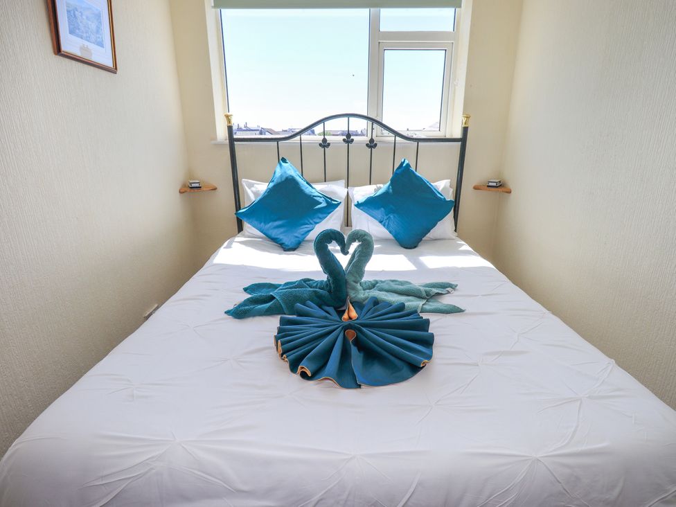 A bedroom with a bed and decorative towel art at The Nest in Lytham St. Annes