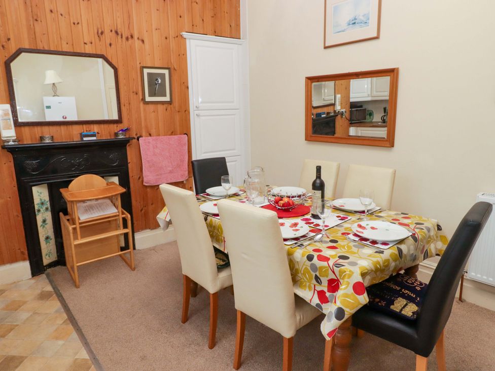 A dining room with a table and chairs at Gwylan Maisonette Tenby