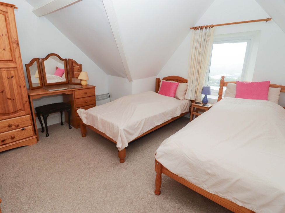 A bedroom with two beds and a dresser at Gwylan Maisonette in Tenby