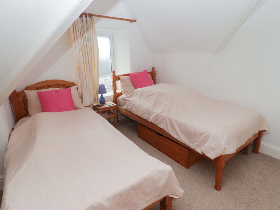 A bedroom with two single beds and a nightstand at Gwylan Maisonette in Tenby