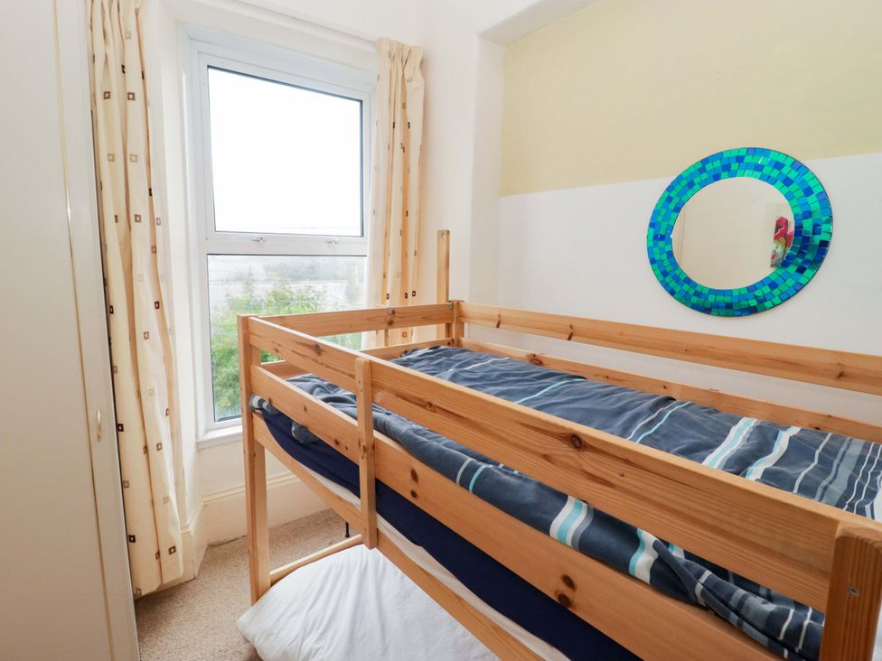 A bedroom with a bunk bed and a window at Gwylan Maisonette in Tenby