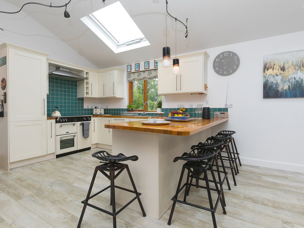 A kitchen with a countertop and bar stools at Branock, Tor Down Quarry St Breward