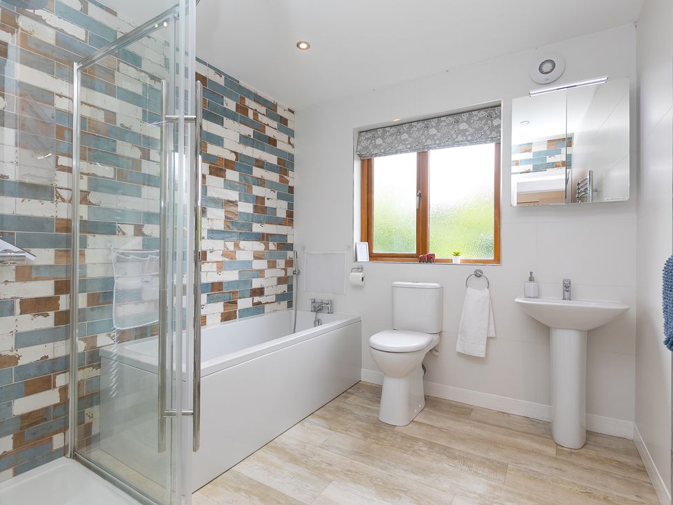 A bathroom with shower, bathtub, toilet and sink at Branock, Tor Down Quarry St Breward
