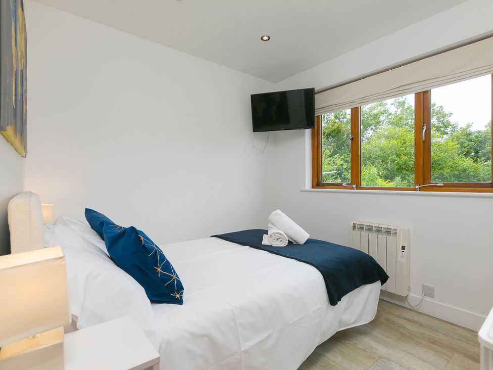 A bedroom with a bed and window at Branock, Tor Down Quarry in St Breward