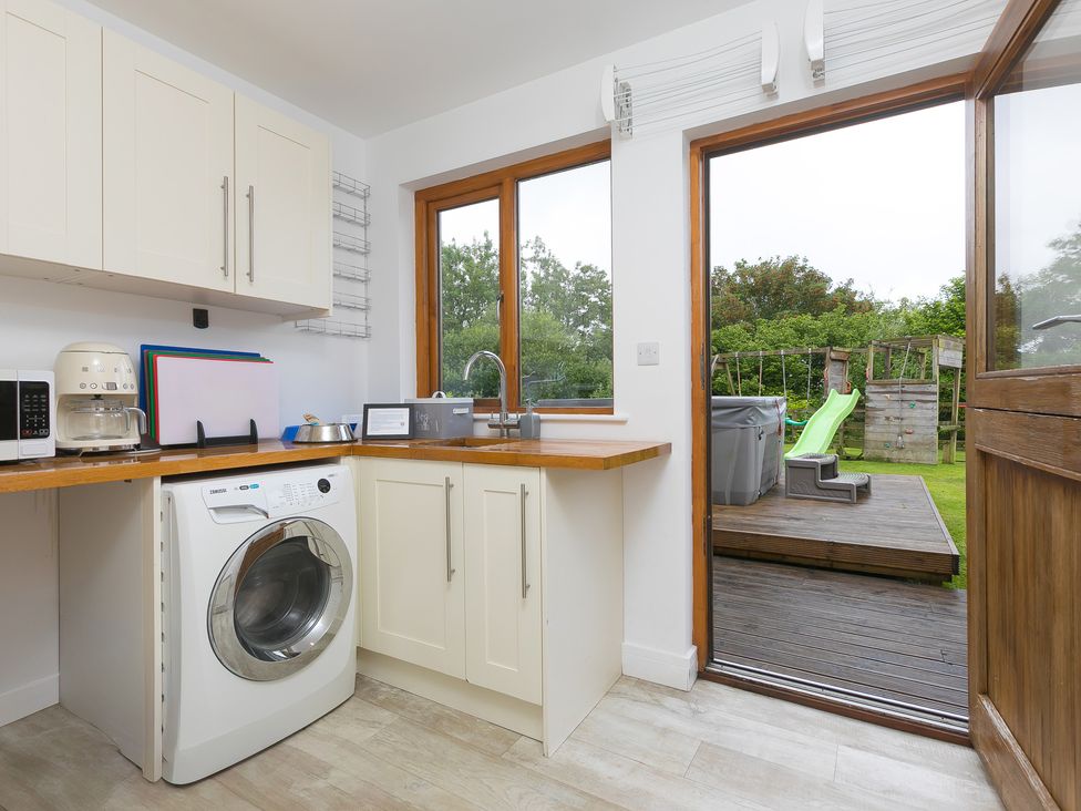 A kitchen with a washing machine and sink at Branock, Tor Down Quarry St Breward