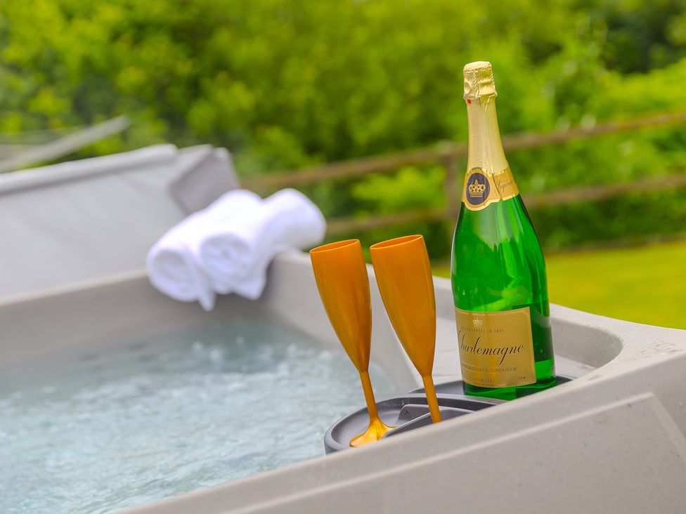 A hot tub with champagne and glasses at Branock, Tor Down Quarry, St Breward