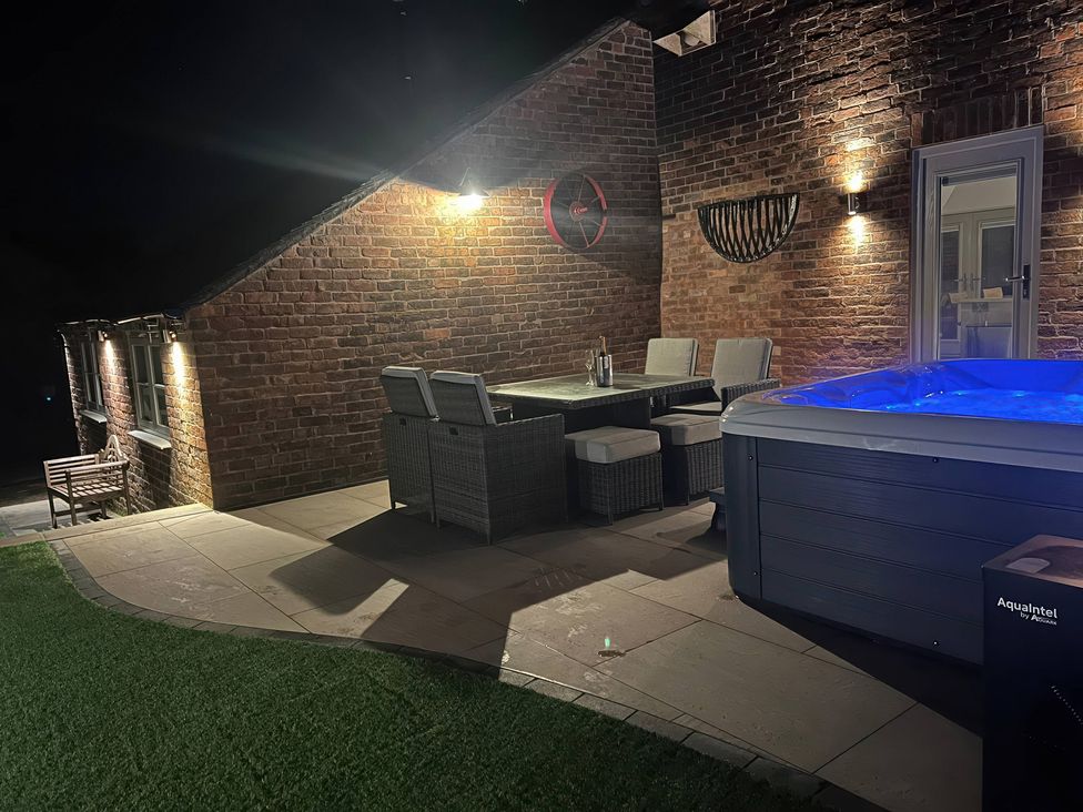 An outdoor terrace with a hot tub and seating area at Small Lane Barn Blackwood Hill near Endon