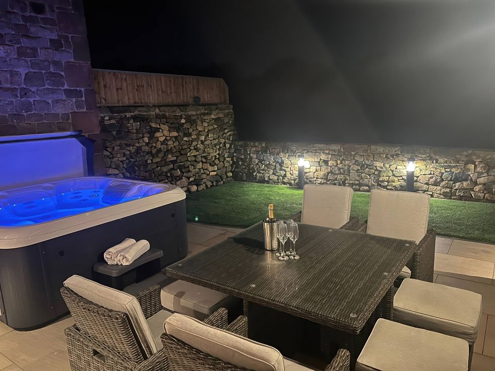 An outdoor area with a hot tub and dining set at Small Lane Barn Blackwood Hill near Endon