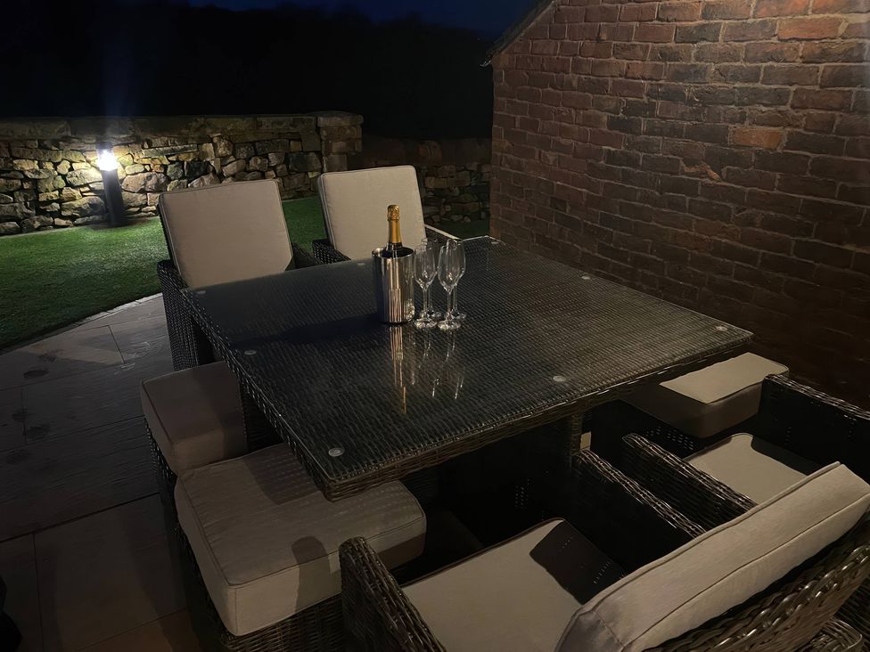 An outdoor seating area with a table and chairs at Small Lane Barn Blackwood Hill near Endon