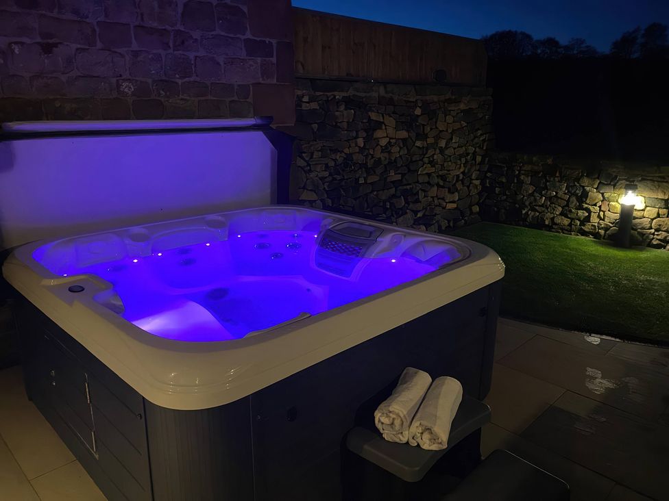 A hot tub with purple lighting in an outdoor area at Small Lane Barn Blackwood Hill near Endon