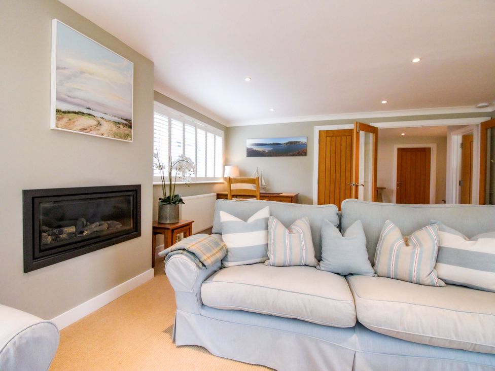 A living room with a sofa and fireplace at Welsummer in Salcombe
