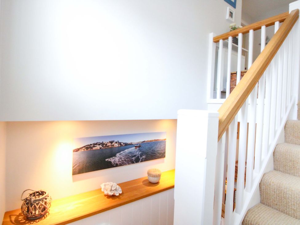 A stairway with a decorative shelf and photo at Welsummer Salcombe