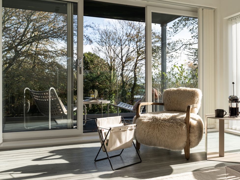 A living room with a chair and table at Estuary Watch in Lelant near Carbis Bay