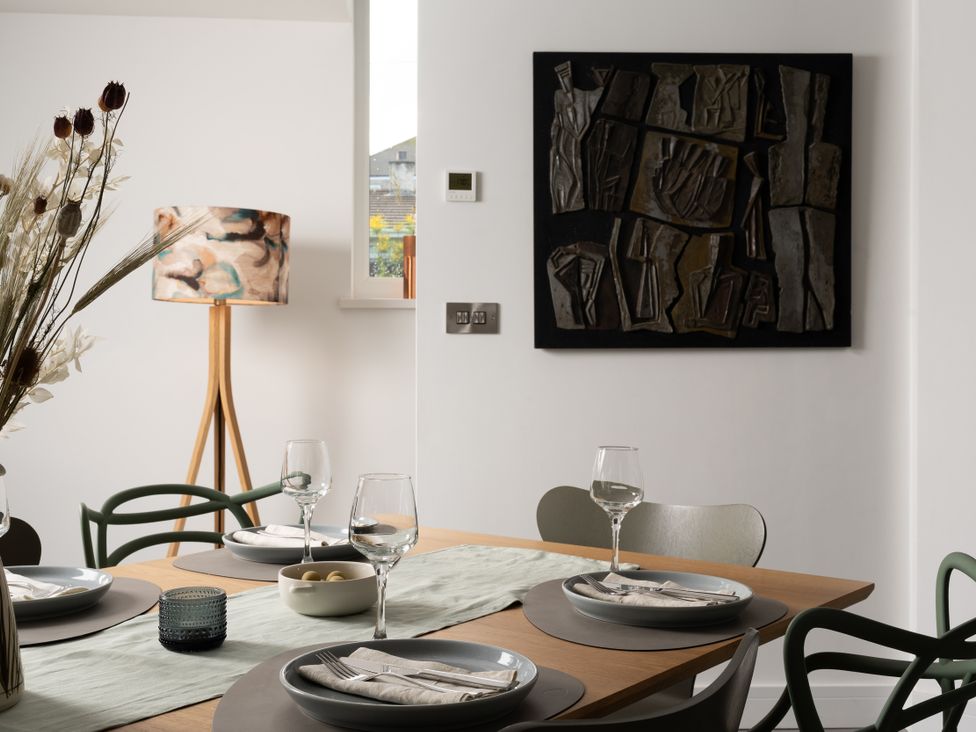 A dining room with a table set for a meal at Estuary Watch in Lelant near Carbis Bay