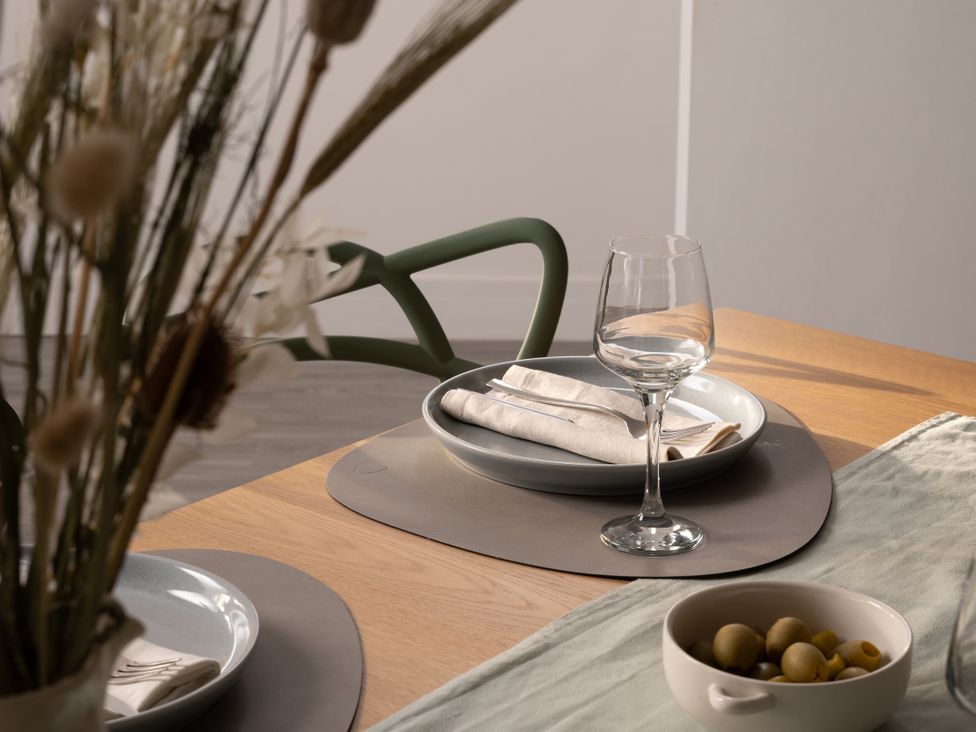 A dining table set with plates and glassware at Estuary Watch Lelant near Carbis Bay