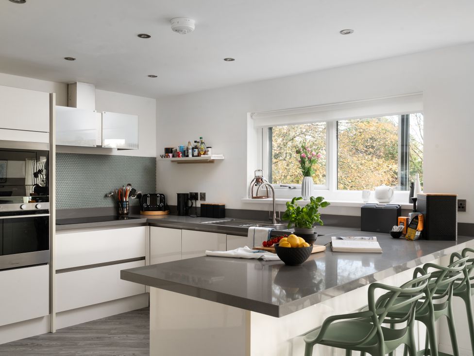 A kitchen with a countertop and bar stools at Estuary Watch Lelant near Carbis Bay