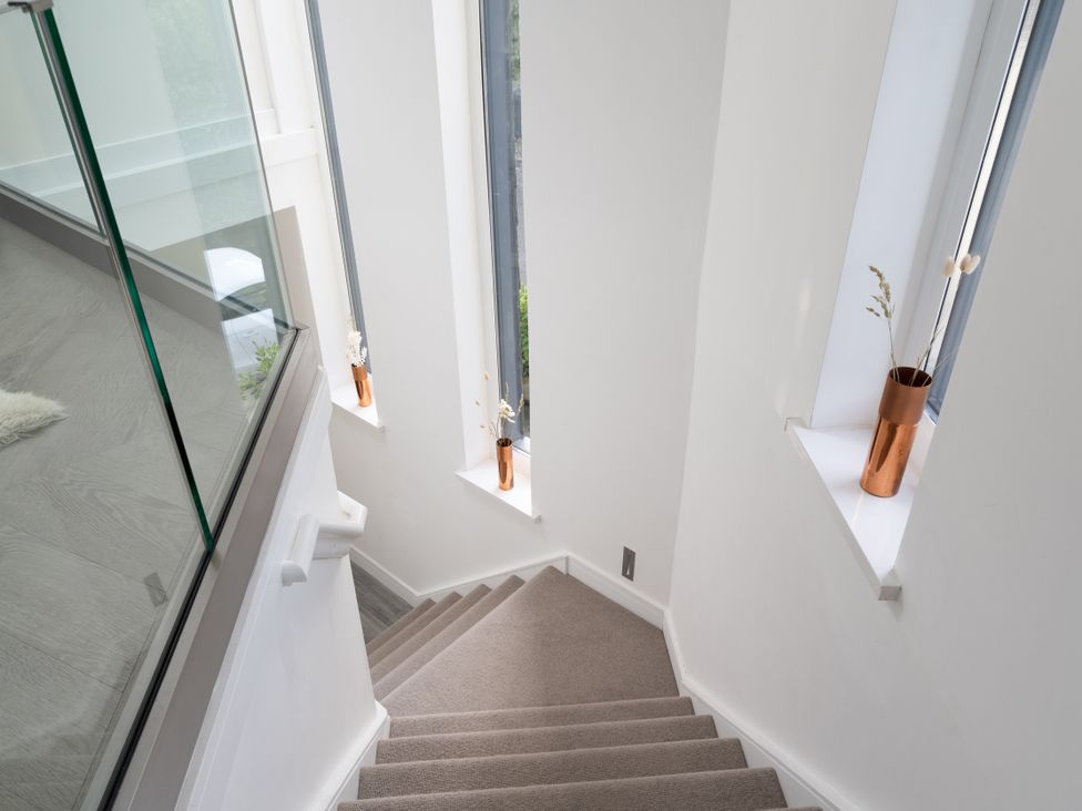 A stairway with windows and a vase at Estuary Watch Lelant near Carbis Bay