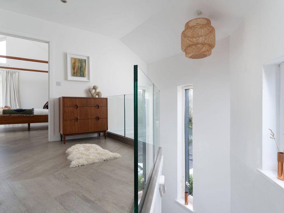 A hallway with a drawer unit and wall art at Estuary Watch in Lelant near Carbis Bay