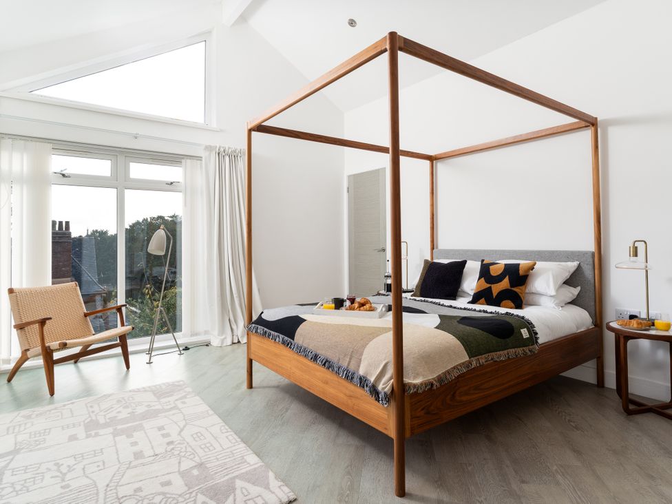 A bedroom with a four-poster bed and a chair at Estuary Watch in Lelant near Carbis Bay