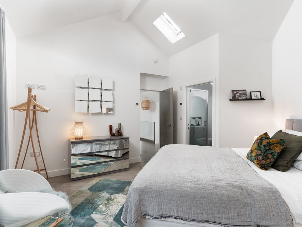 A bedroom featuring a bed with cushions and a dresser at Estuary Watch Lelant near Carbis Bay