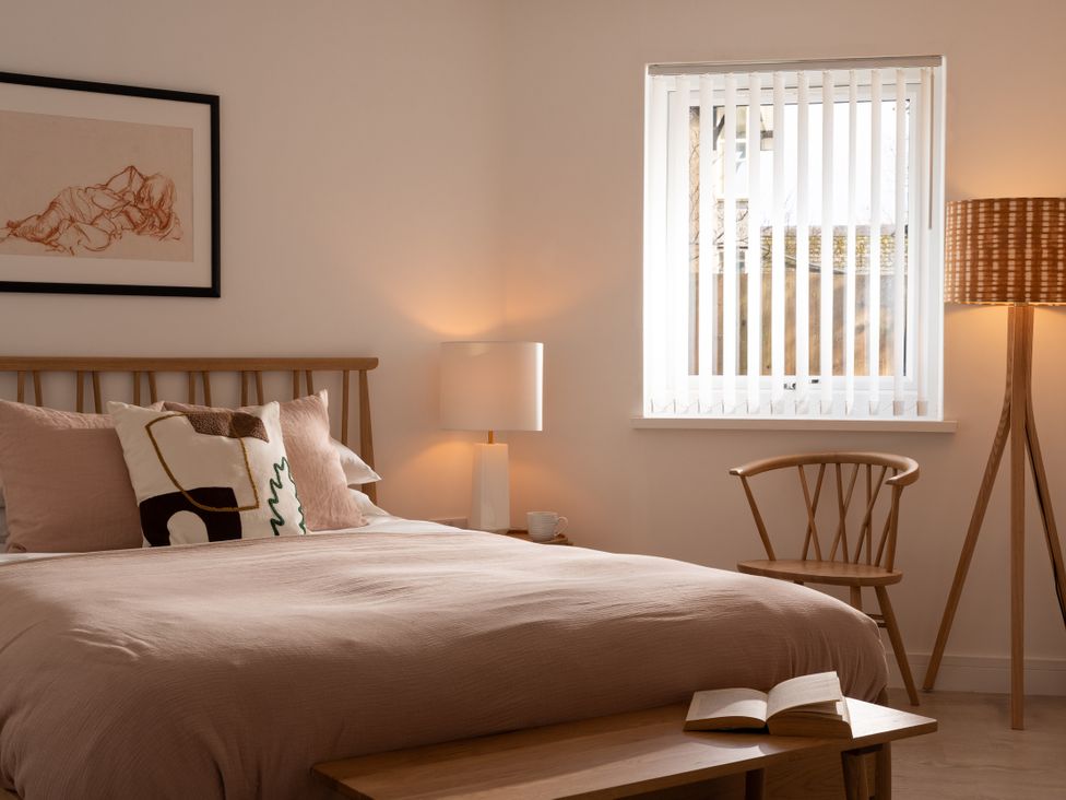 A bedroom with a bed, lamp, chair, and table at Estuary Watch in Lelant near Carbis Bay