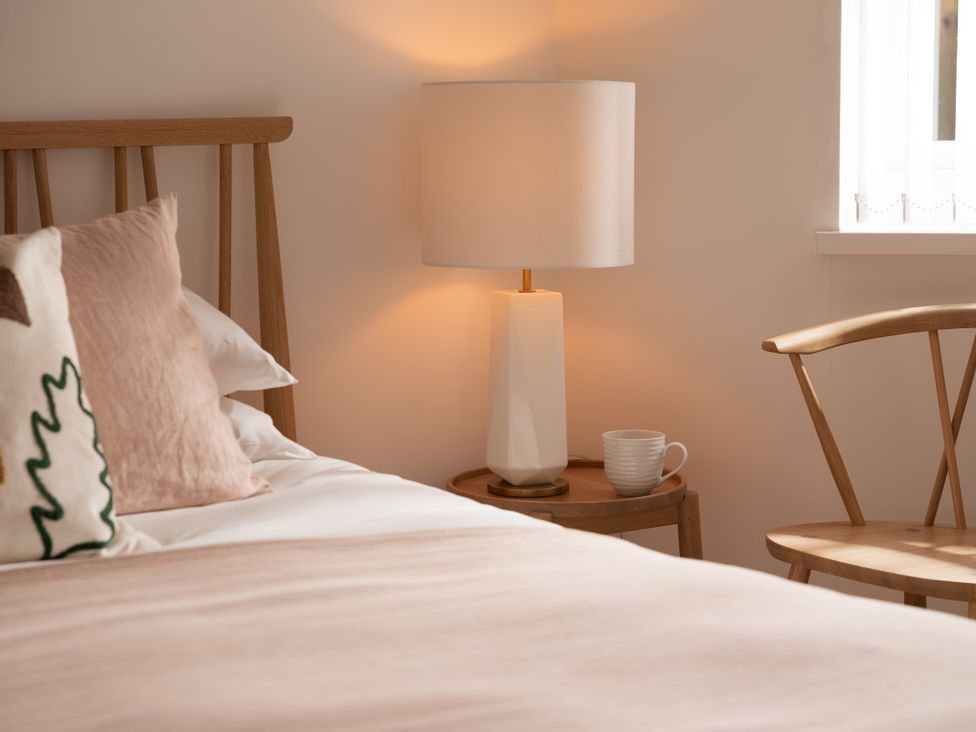 A bedroom with a bed and lamp at Estuary Watch Lelant near Carbis Bay