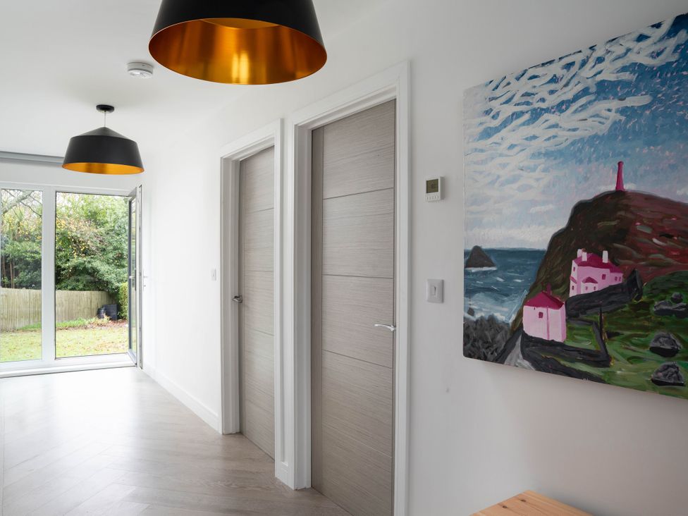 A hallway with doors and a painting at Estuary Watch Lelant near Carbis Bay