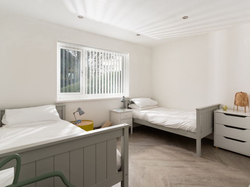 A bedroom with two beds and a window at Estuary Watch in Lelant near Carbis Bay
