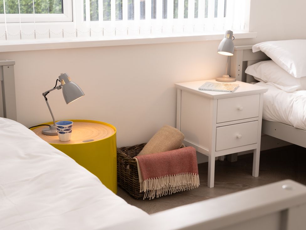 A bedroom with two beds and bedside tables at Estuary Watch in Lelant near Carbis Bay